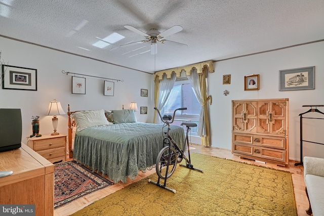 bedroom featuring ceiling fan, hardwood / wood-style floors, and a textured ceiling