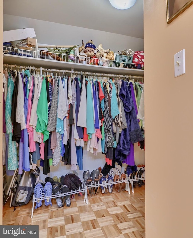 spacious closet featuring parquet flooring