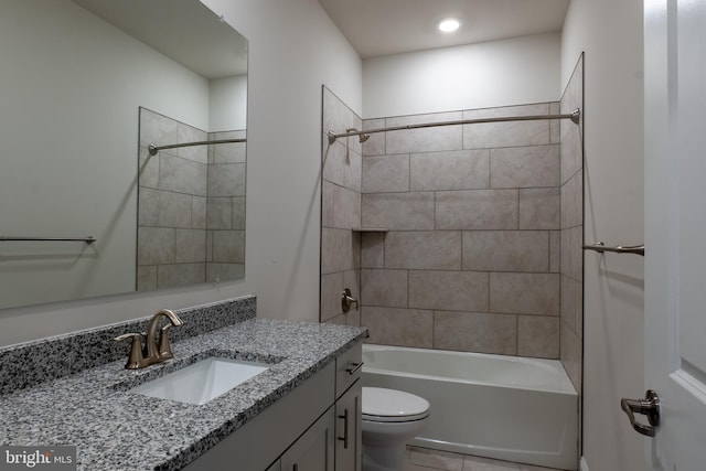 full bathroom featuring vanity, toilet, tiled shower / bath, and tile patterned flooring