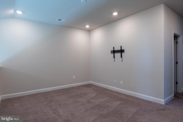 spare room with carpet flooring and vaulted ceiling