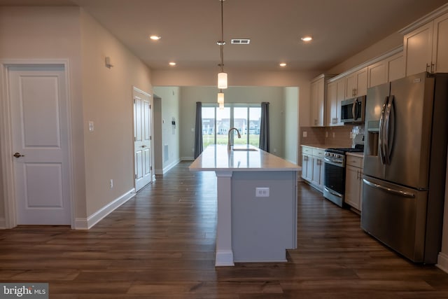 kitchen featuring dark hardwood / wood-style floors, stainless steel appliances, a kitchen island with sink, and sink