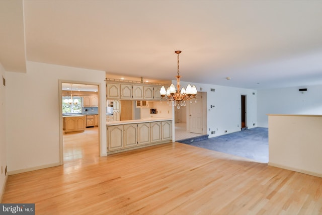 unfurnished dining area with a notable chandelier and light wood-type flooring