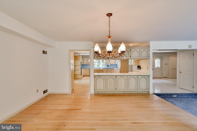 kitchen with light wood-type flooring, decorative light fixtures, and a chandelier