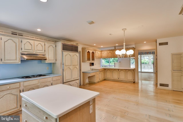 kitchen with light hardwood / wood-style flooring, white gas cooktop, a chandelier, pendant lighting, and a kitchen island