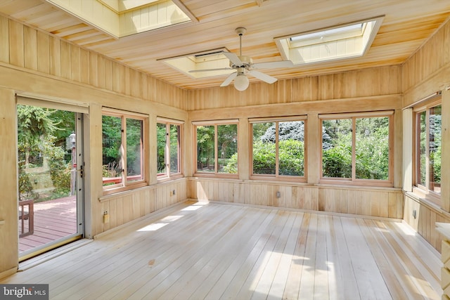 unfurnished sunroom with ceiling fan, wooden ceiling, and a skylight