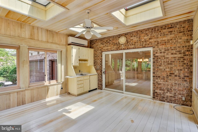 unfurnished sunroom with wooden ceiling, a skylight, a wall unit AC, and ceiling fan