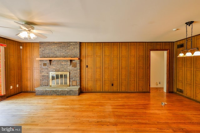 unfurnished living room featuring a fireplace, hardwood / wood-style floors, and ceiling fan