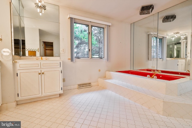 bathroom with tile patterned flooring, tiled bath, and vanity