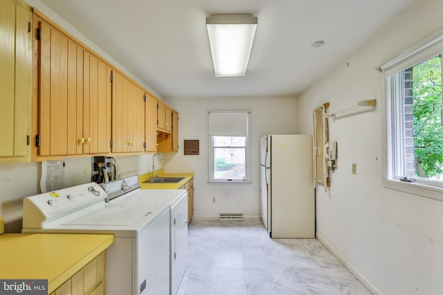 washroom featuring a wealth of natural light, sink, and washer and dryer