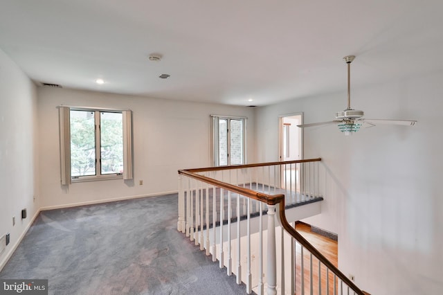 hall with dark colored carpet