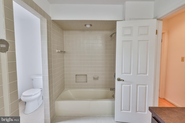 full bathroom with tile patterned flooring, toilet, tiled shower / bath combo, and vanity