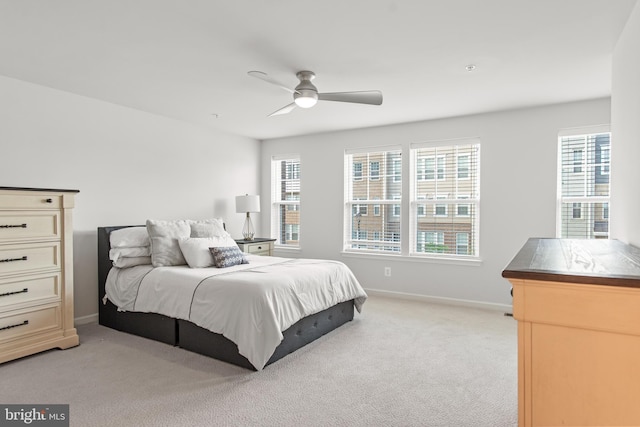 carpeted bedroom featuring multiple windows and ceiling fan