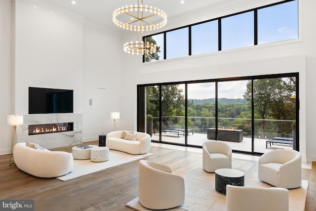 living room featuring wood-type flooring, a chandelier, and ornamental molding