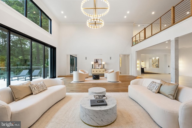 living room featuring a high ceiling, light hardwood / wood-style flooring, and a notable chandelier