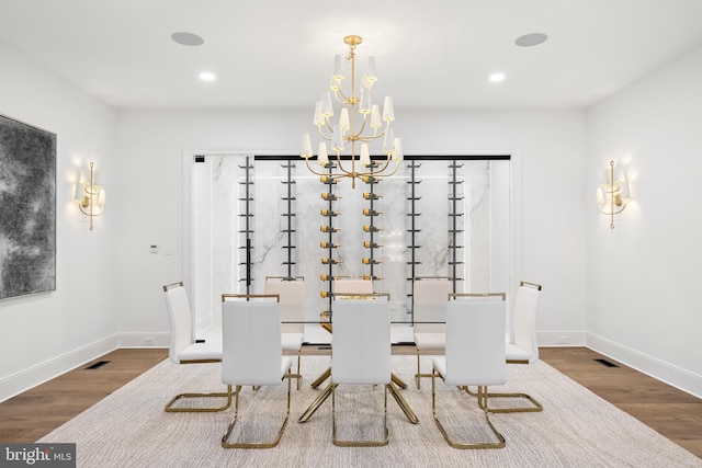 dining area featuring wood-type flooring and a notable chandelier