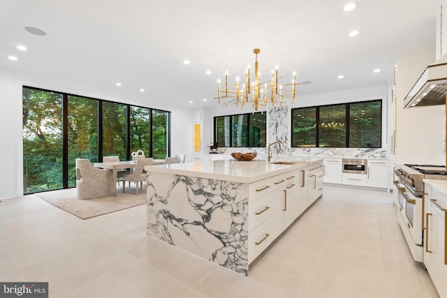 kitchen with decorative light fixtures, white cabinets, stainless steel range, and a spacious island