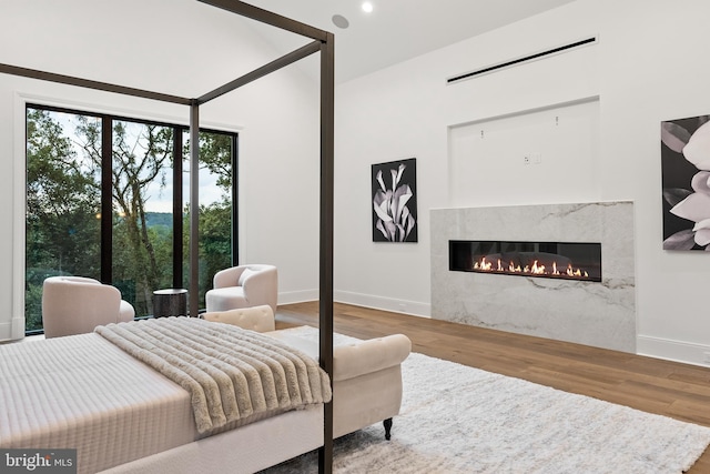 bedroom featuring wood-type flooring and a premium fireplace