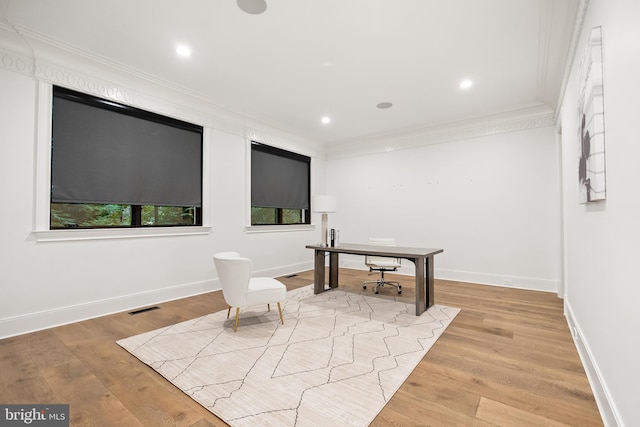 home office featuring crown molding and light hardwood / wood-style floors