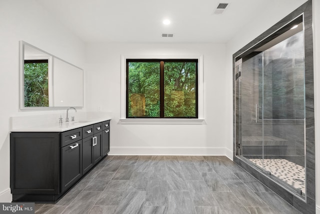 bathroom with a shower with door and vanity