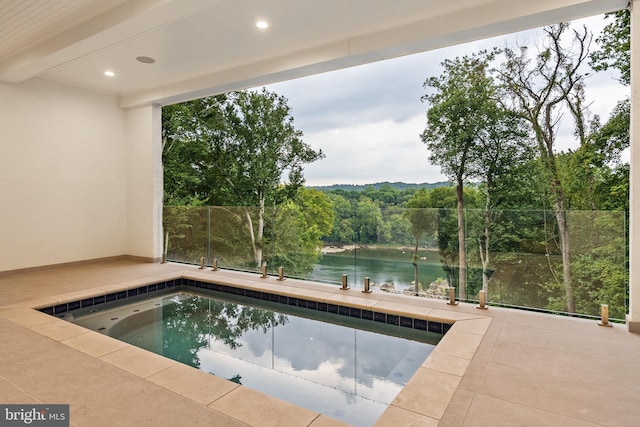 view of pool featuring a water view and a patio