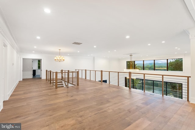 hallway featuring light wood-type flooring and crown molding