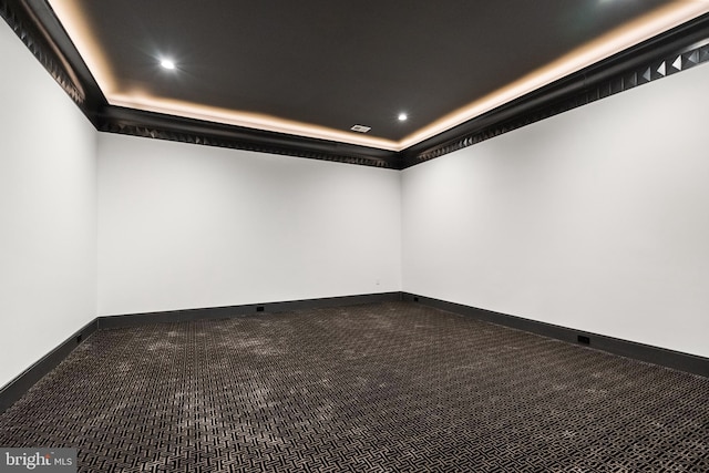 carpeted spare room with a raised ceiling