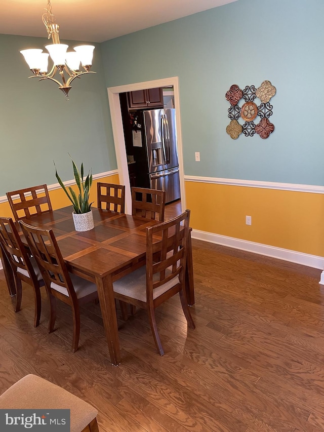 dining area featuring wood-type flooring and an inviting chandelier