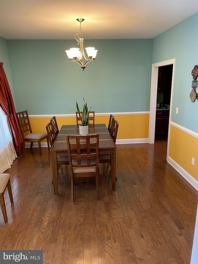 dining room featuring dark hardwood / wood-style floors and a chandelier