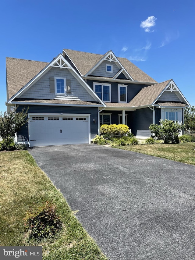 craftsman house featuring a front yard and a garage