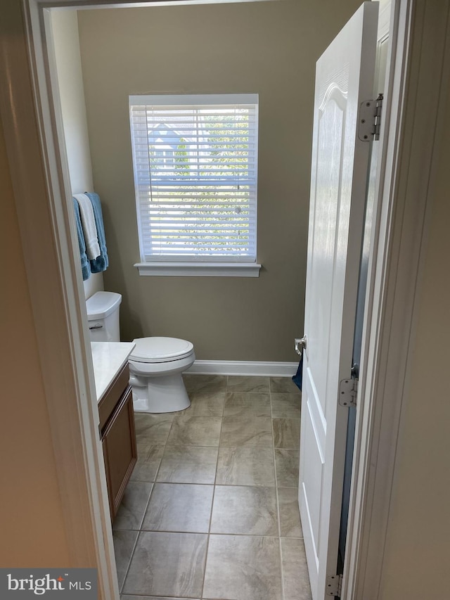 bathroom featuring tile patterned flooring, vanity, and toilet