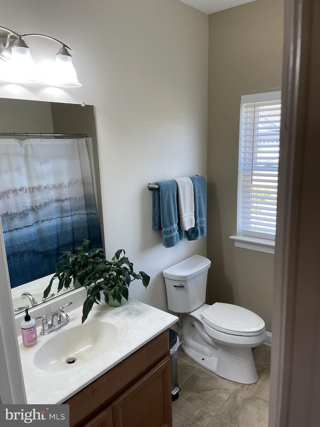 bathroom with tile patterned flooring, vanity, and toilet