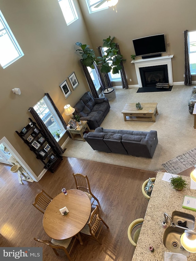 living room with ceiling fan and a towering ceiling