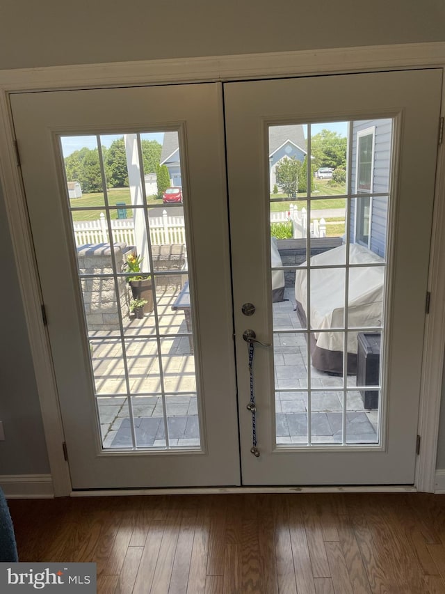 doorway with dark hardwood / wood-style flooring, french doors, and plenty of natural light