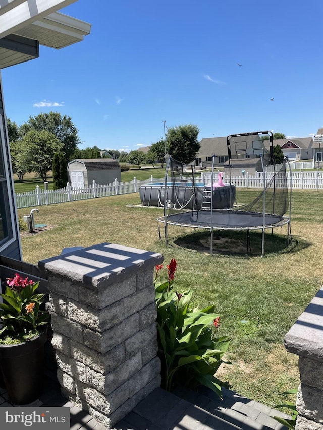 view of yard with a fenced in pool and a trampoline