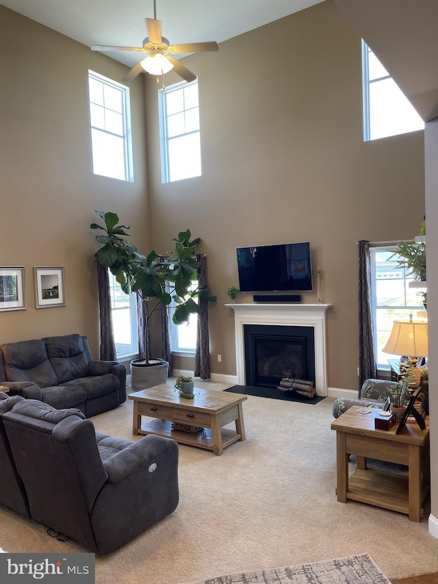 carpeted living room featuring a high ceiling and ceiling fan