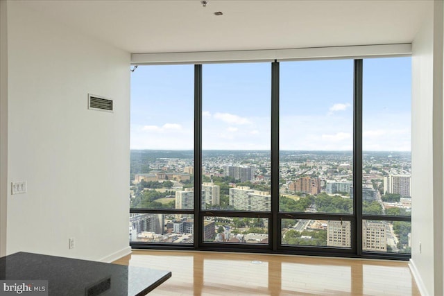 interior space with floor to ceiling windows, a healthy amount of sunlight, and hardwood / wood-style flooring