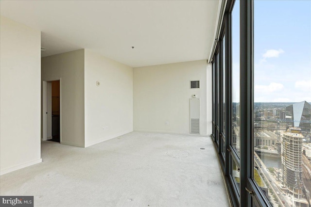 spare room featuring a water view and light colored carpet