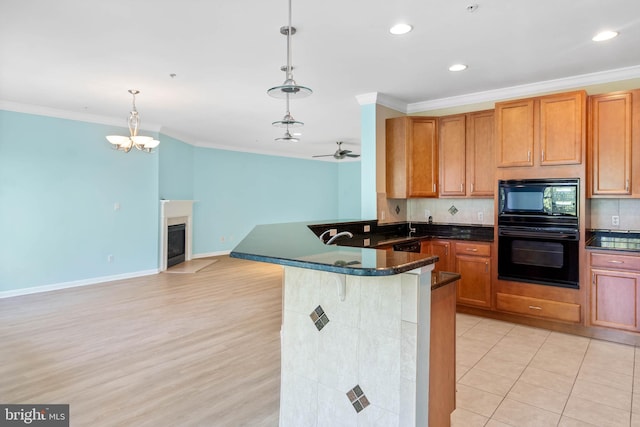 kitchen with decorative backsplash, pendant lighting, ceiling fan with notable chandelier, and kitchen peninsula