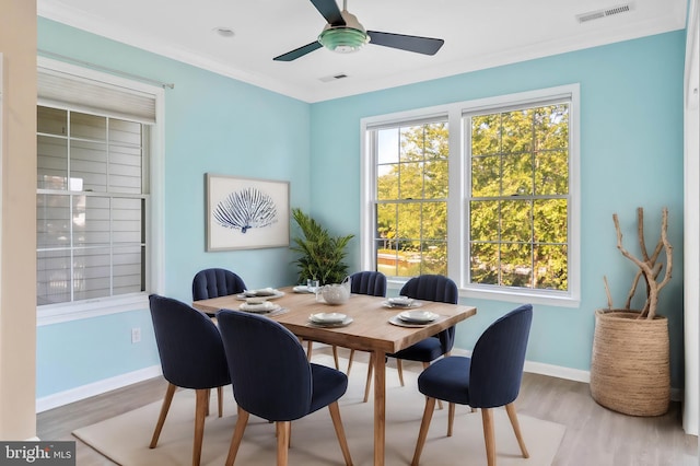 dining area with crown molding, hardwood / wood-style floors, and plenty of natural light