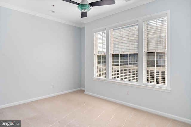 carpeted spare room featuring ceiling fan and crown molding