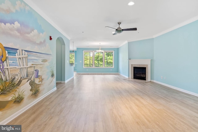 unfurnished living room featuring ornamental molding, a fireplace, ceiling fan, and light wood-type flooring