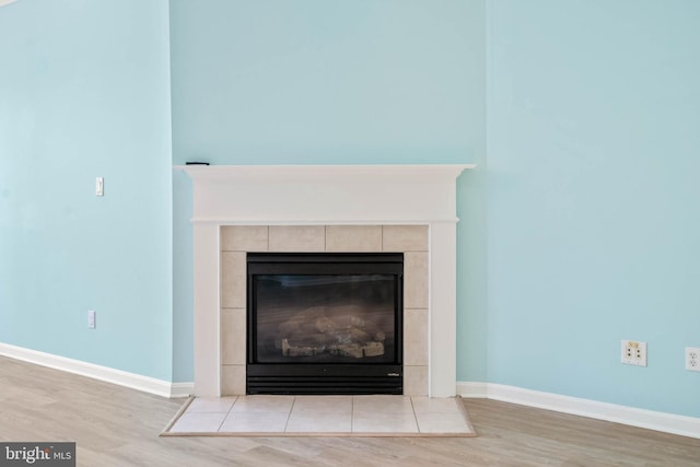 room details featuring a tile fireplace and hardwood / wood-style floors