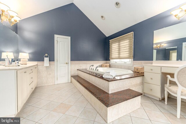 bathroom with tile patterned flooring, vanity, a bath, and tile walls