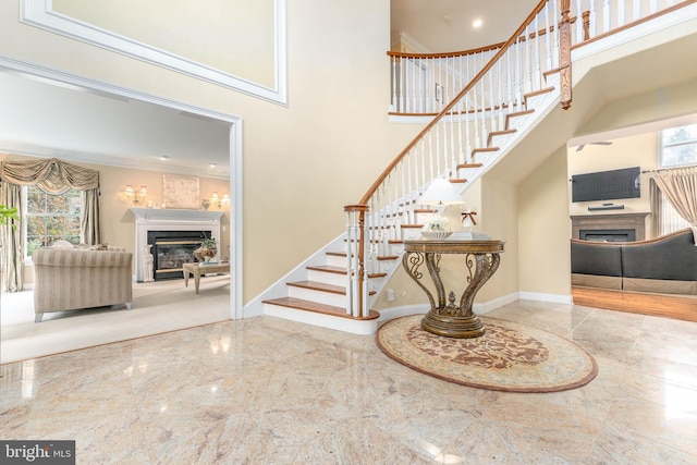 staircase with a wealth of natural light, a high ceiling, and ornamental molding