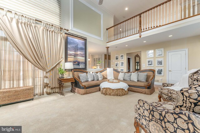 living room with carpet flooring, a towering ceiling, and ornamental molding