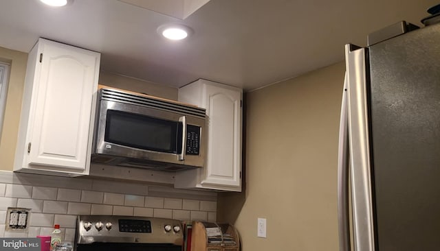 kitchen featuring white cabinets, stainless steel appliances, and tasteful backsplash