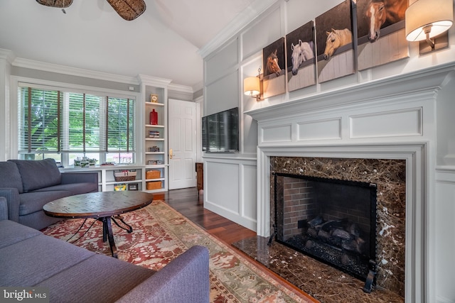 living room featuring dark hardwood / wood-style floors, ceiling fan, crown molding, and a high end fireplace