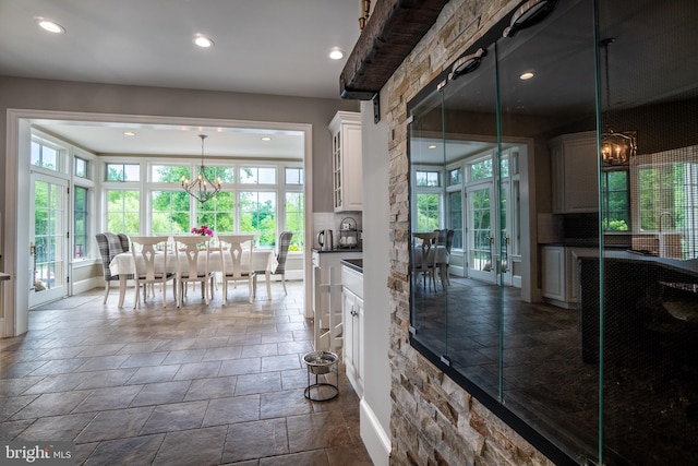 kitchen featuring white cabinetry, french doors, hanging light fixtures, and a notable chandelier