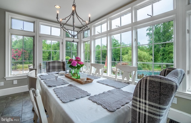 sunroom / solarium featuring an inviting chandelier