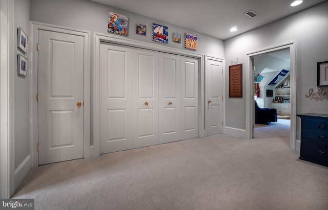 unfurnished bedroom with light carpet and a closet